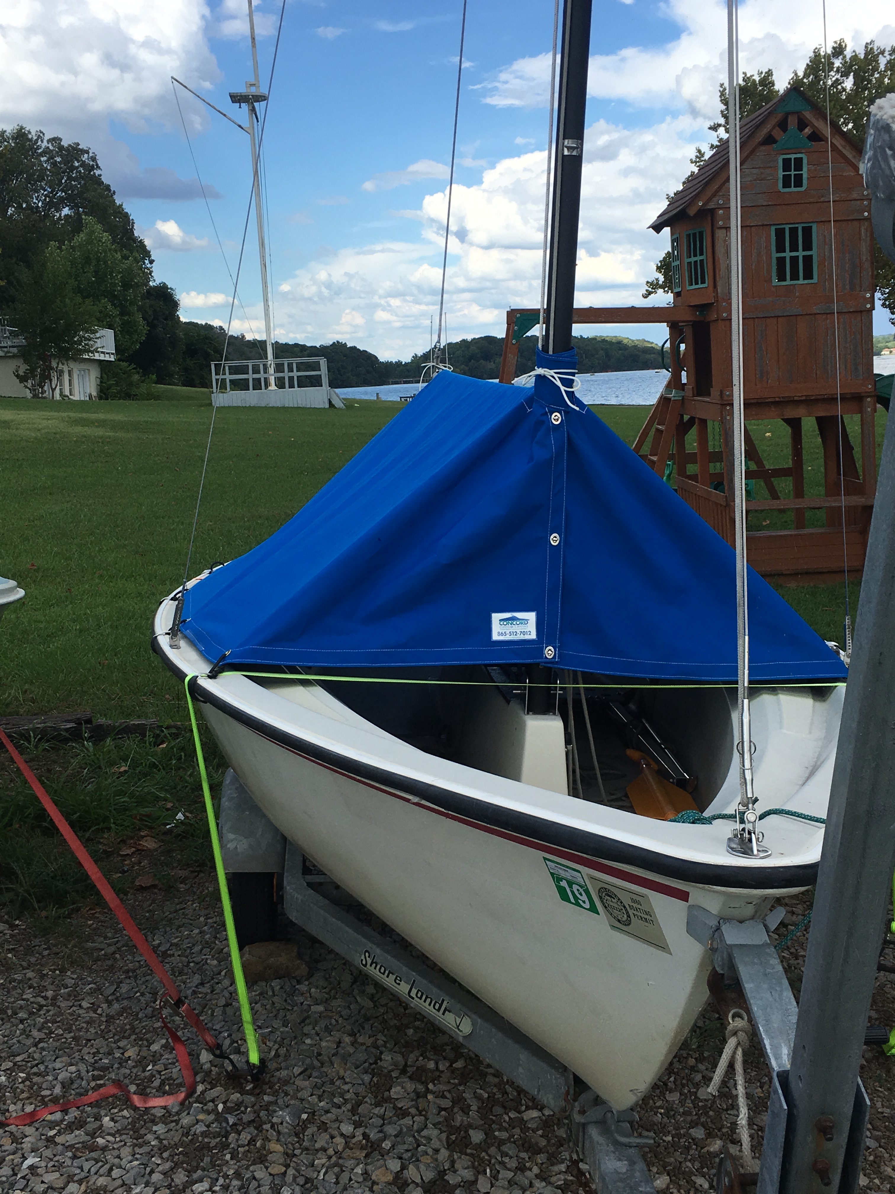 Sailboat with custom boom cover and metal bracket attachments.